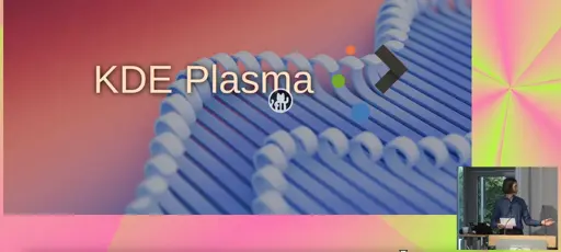A view of a slide depicting KDE Plasma 6.4. MA Barbe, the speaker, can be seen in an inset in the bottom right hand corner.