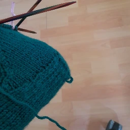 le talon d'une chaussette vert forêt, ou une petite boucle dépasse juste au pire endroit. 