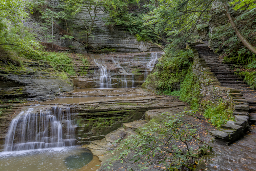 Stairs wrap around this multiple tiered, wide waterfall along Buttermilk Creek.