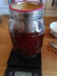 Ein großes Schraubglas mit einem Kaffeefilter darin.