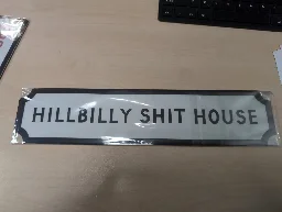 A sign that reads "hillbilly shithouse"