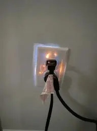 photo of an electrical socket, behind the plastic cover the wires glow bright orange. blue flashes escape from the edges of the cover