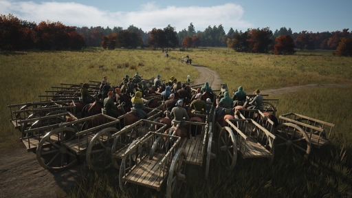 A large group of wooden carts, pulled by people in medieval-style clothing, in a grassy field with few roads.