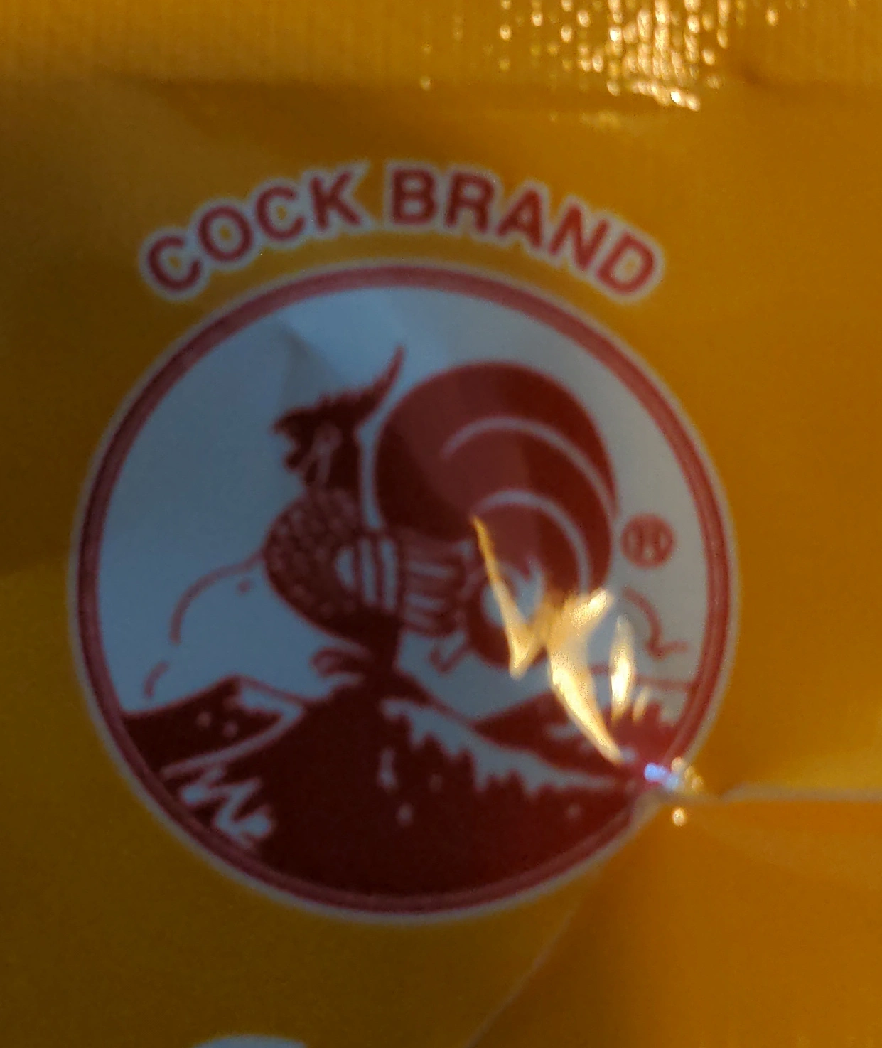 logo of a company called "cock brand": a rooster on a mountain, the name of the company is written above