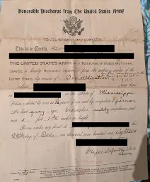 An old, yellowed paper that reads as follows: Honorable Discharge from the United States Army.  To all whom it may concern:  This is to certify, that [redacted for privacy] the United States army, as a testimonial of honest and faithful service, is hereby honorably discharged from the military service of the United States by reason of demobilization for the convenience of the [illegible] Nov. 18, 1918. Said [redacted] was born in [redacted] in the state of Mississippi. When enlisted he was 21 and 7/12 years of age and by occupation a farmer. He had gray eyes, brown hair, ruddy complexion, and was 5 feet 7 and 3/4 inches in height. Given under my hand at [redacted] this 24th day of Dec., one thousand nine hundred and eighteen.  [redacted]. Major Infantry, USA.  Faintly visible at the bottom is a red stamp reading, "Washington, D.C." and some other illegible text.